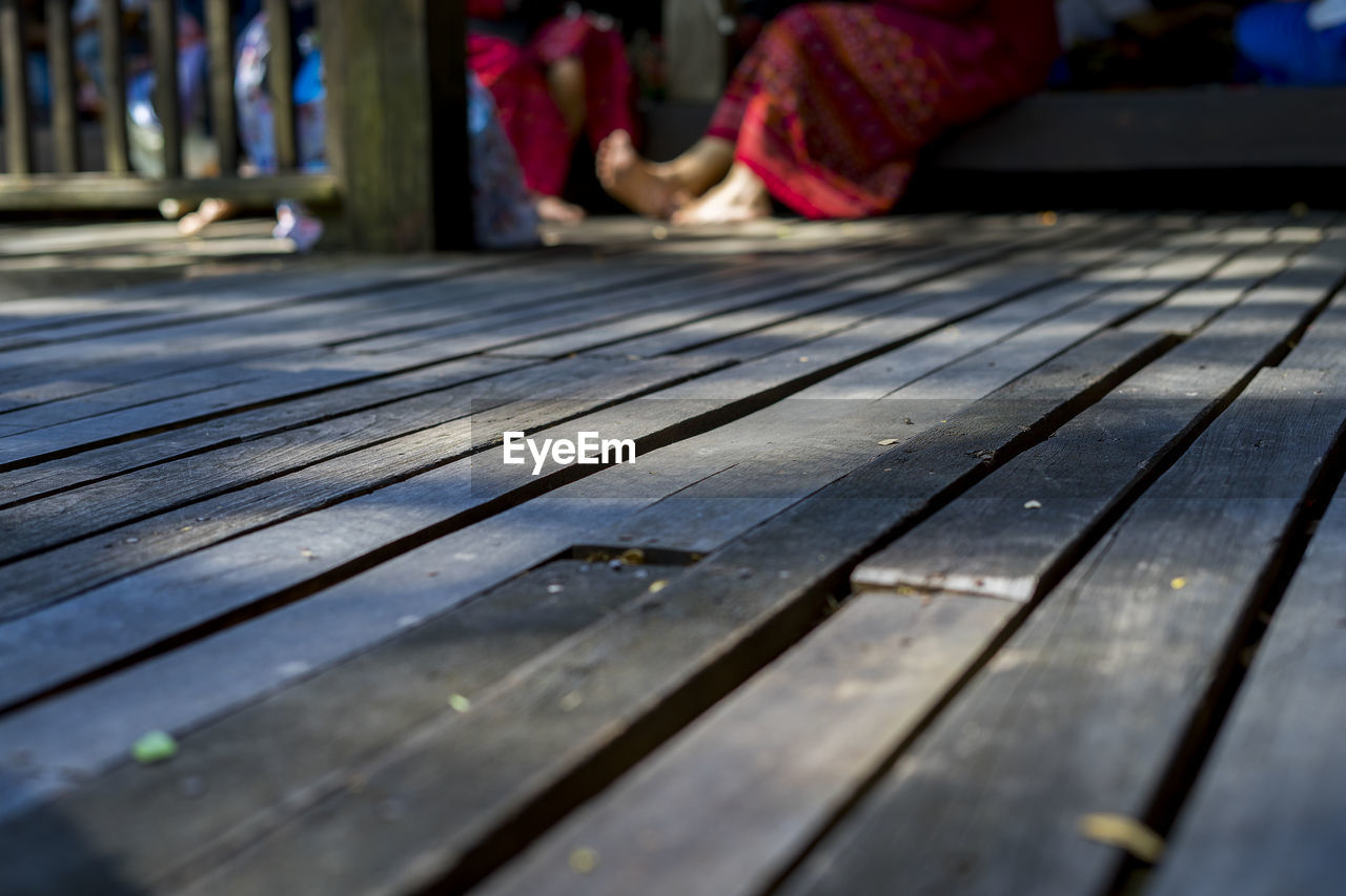 Close-up of wooden bench on footpath