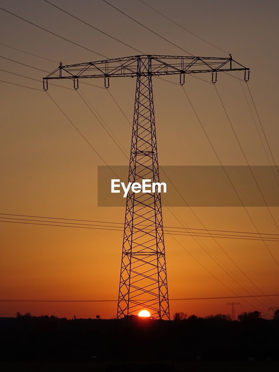 LOW ANGLE VIEW OF ELECTRICITY PYLON AGAINST SKY DURING SUNSET