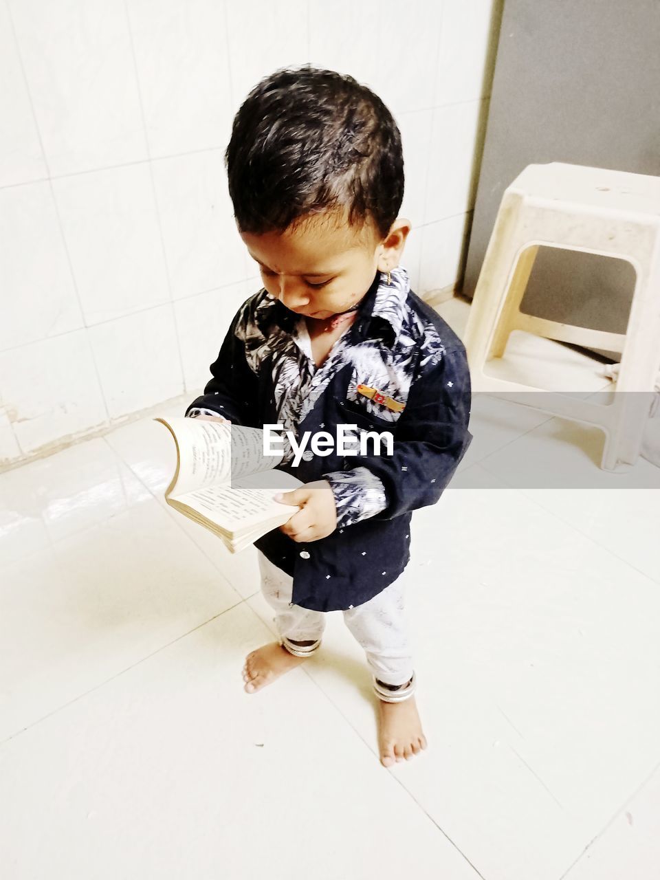 High angle view of cute boy reading book at home