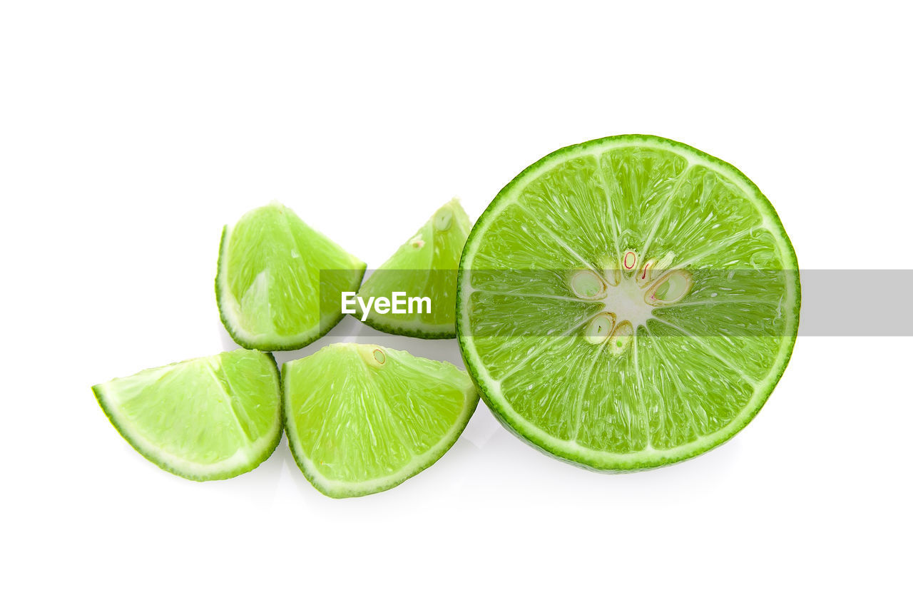 CLOSE-UP OF GREEN LEMON AGAINST WHITE BACKGROUND