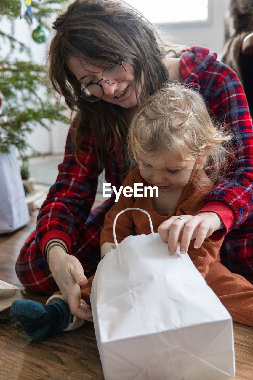 high angle view of mother and daughter sitting on sofa at home