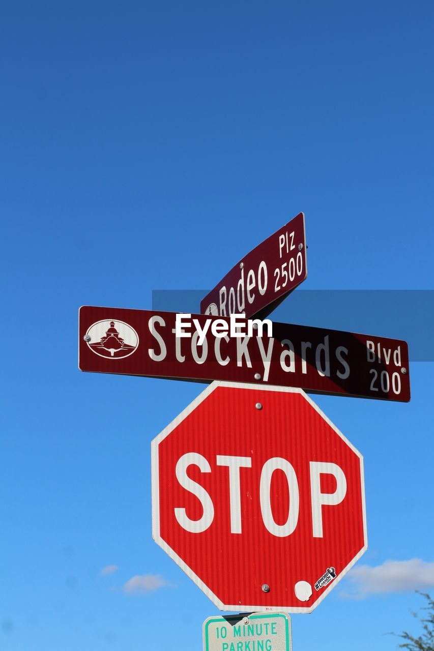 Low angle view of road sign against blue sky