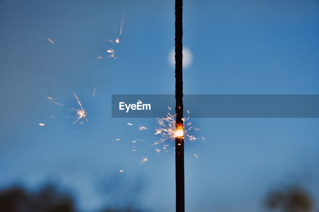 fireworks, sky, motion, illuminated, celebration, nature, event, blurred motion, low angle view, burning, no people, night, long exposure, arts culture and entertainment, smoke, outdoors, glowing, flower, firework display, blue, light, exploding, firework - man made object, fire, clear sky, sparks