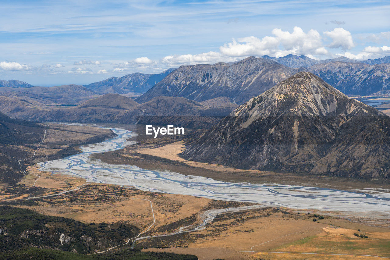 Mountains above a braided river during summer in arthur's pass, new zealand