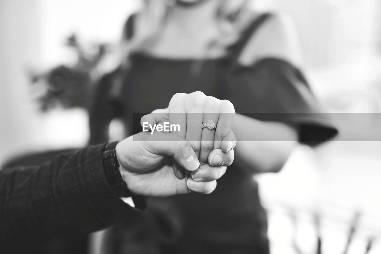 Close-up of bride and groom holding hands