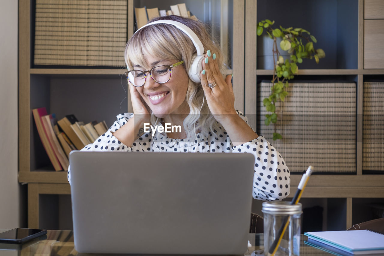 young woman using laptop while sitting at office