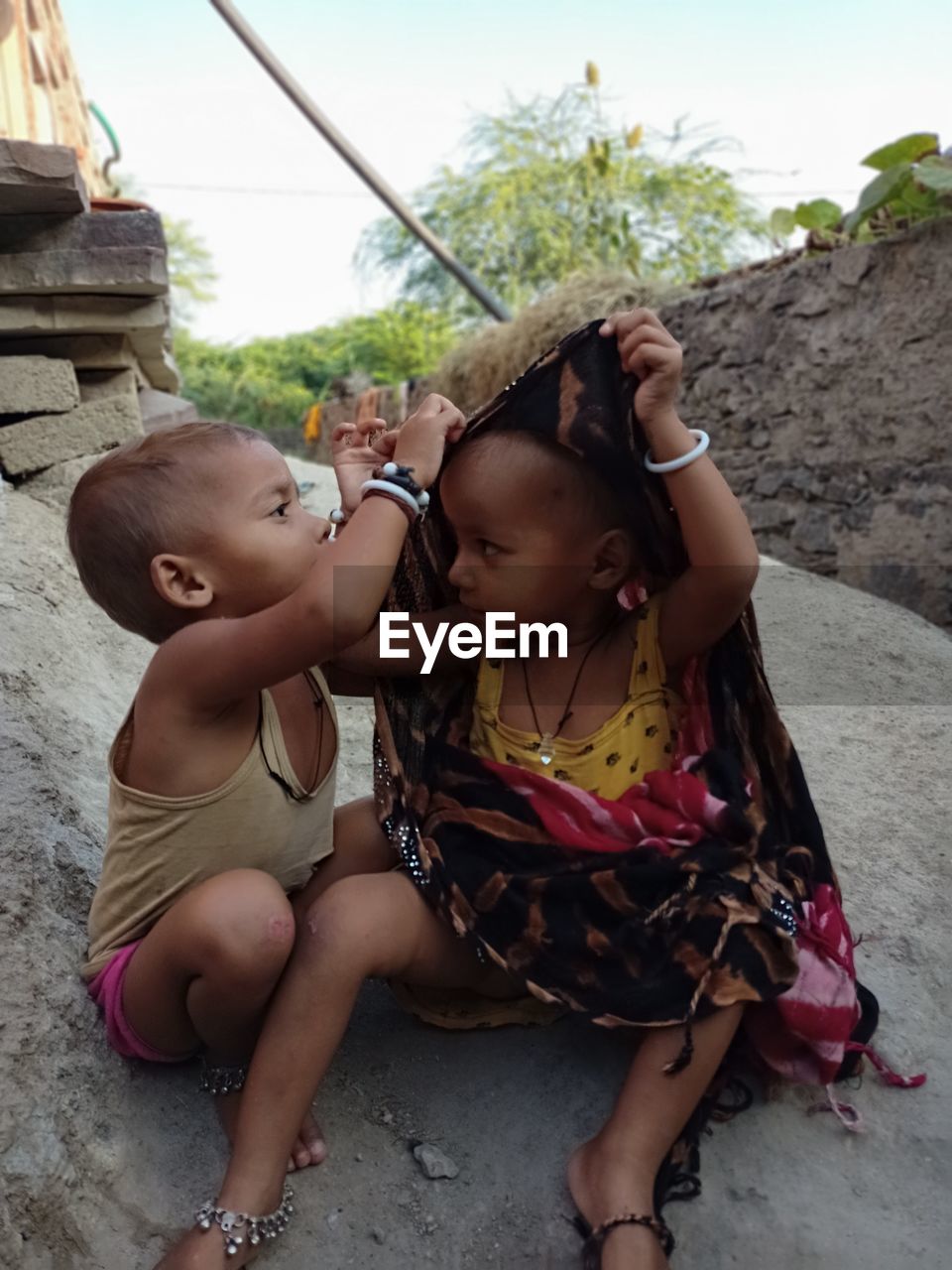 MOTHER AND GIRL SITTING IN TRADITIONAL CLOTHING