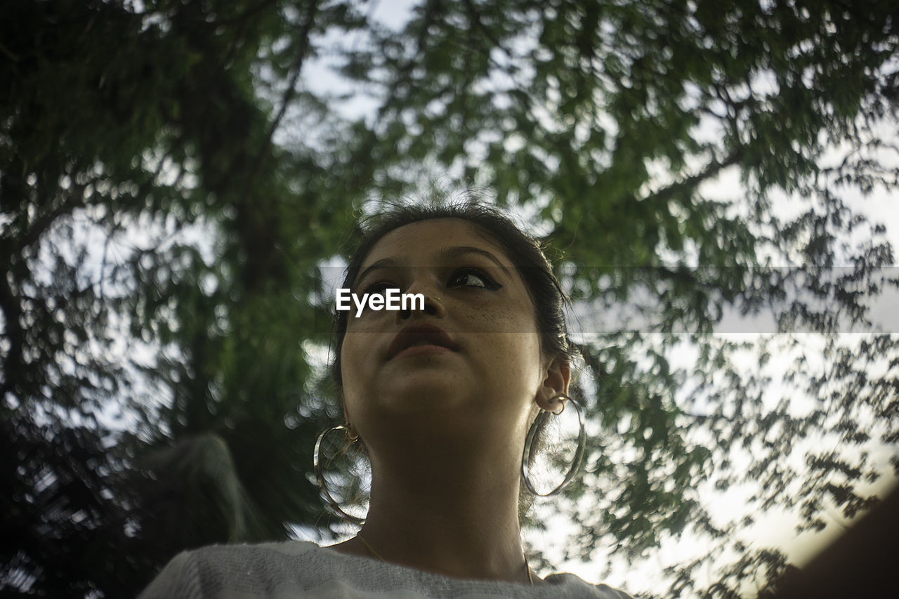 Low angle view of woman against tree