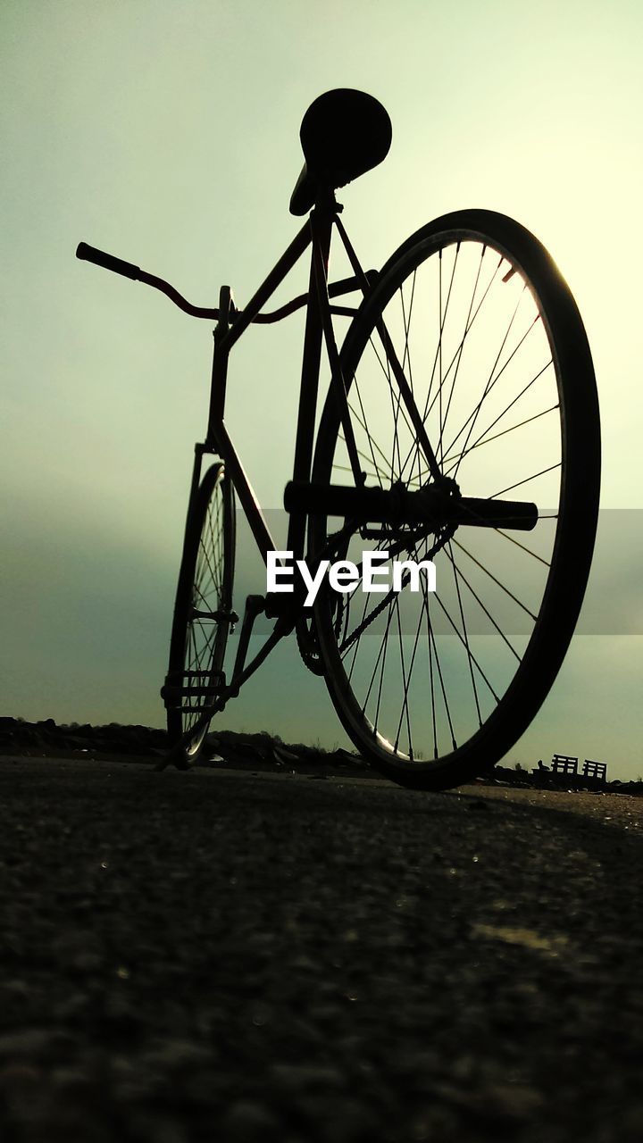 Bicycle parked on field against sky