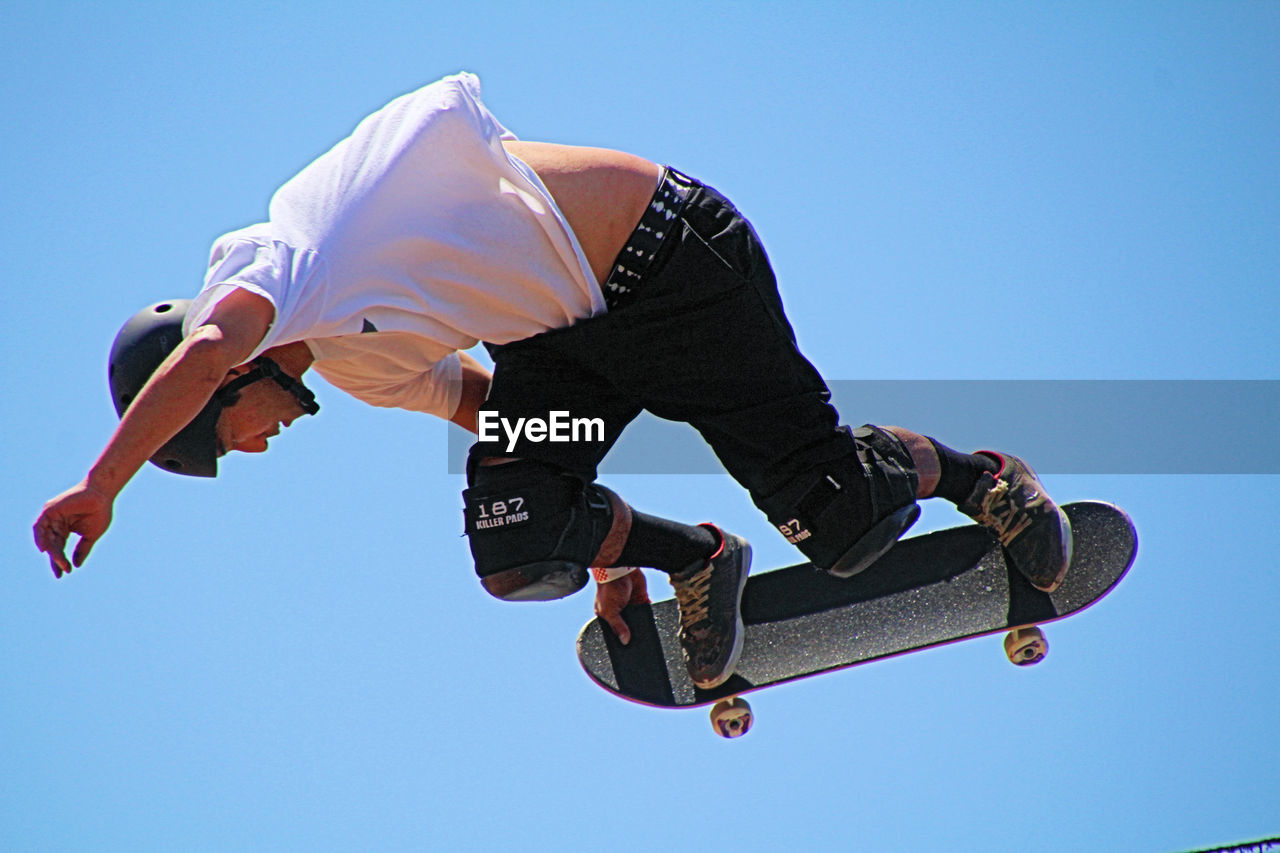 LOW ANGLE VIEW OF MAN PLAYING AGAINST CLEAR SKY