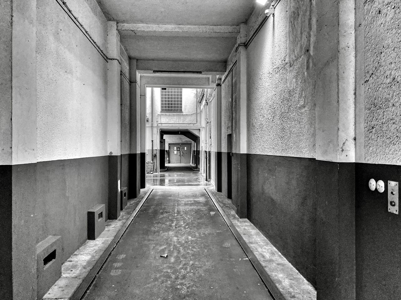 EMPTY CORRIDOR ALONG BUILDINGS