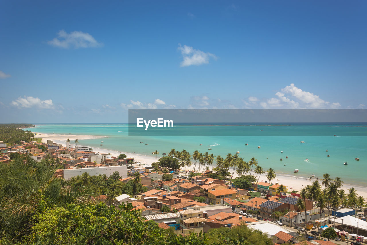 High angle view of buildings by sea against sky