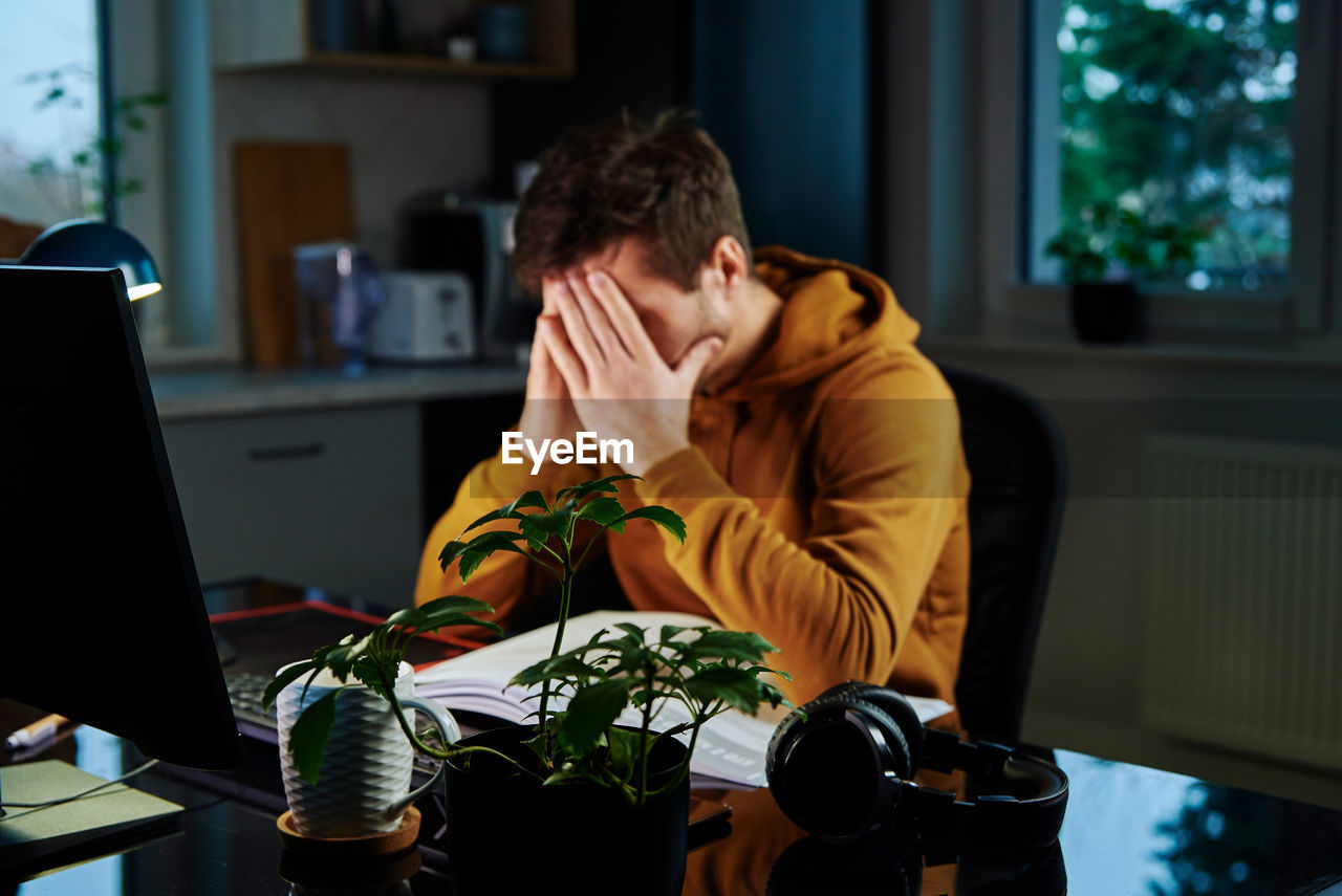 Tired man works late at workplace in the night