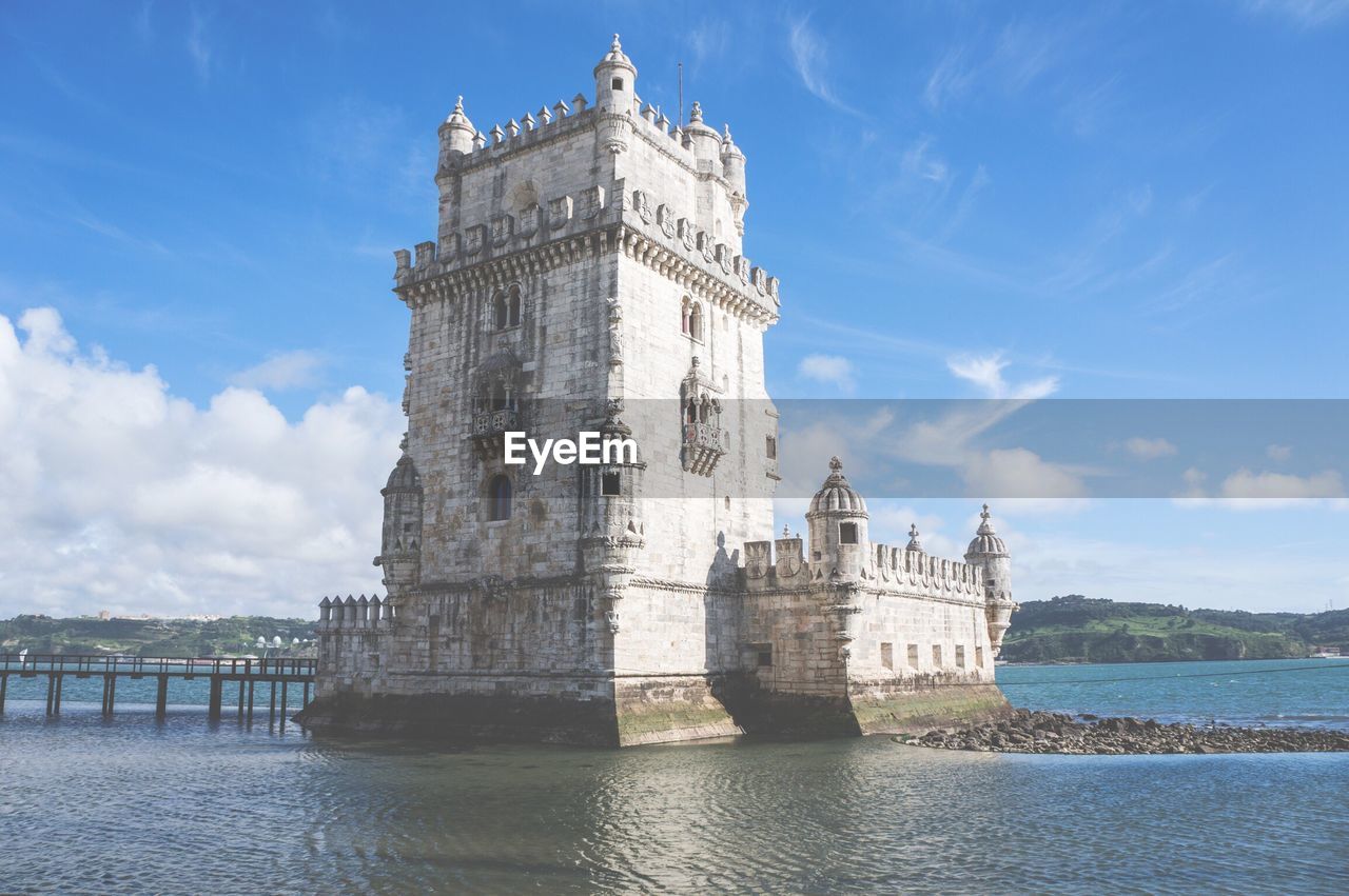 Torre de belem amidst tagus river against sky