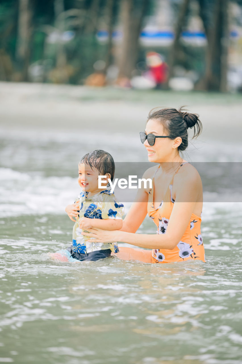 full length of shirtless man swimming in sea