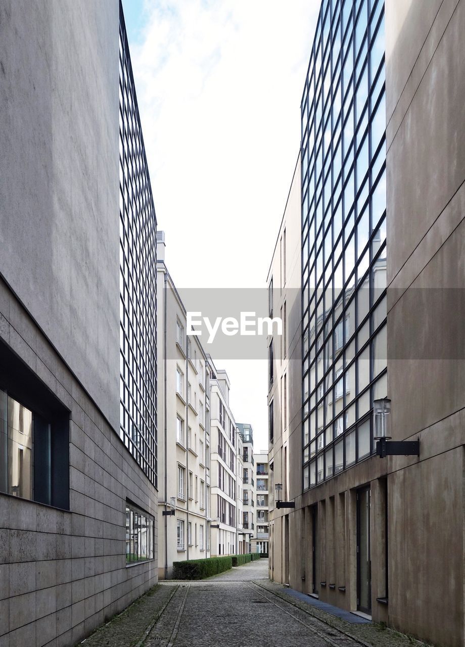 LOW ANGLE VIEW OF BUILDINGS BY STREET AGAINST SKY