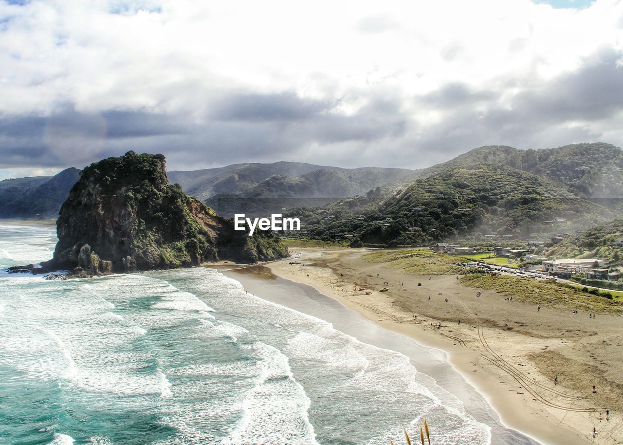 High angle view of rocky beach against cloudy sky