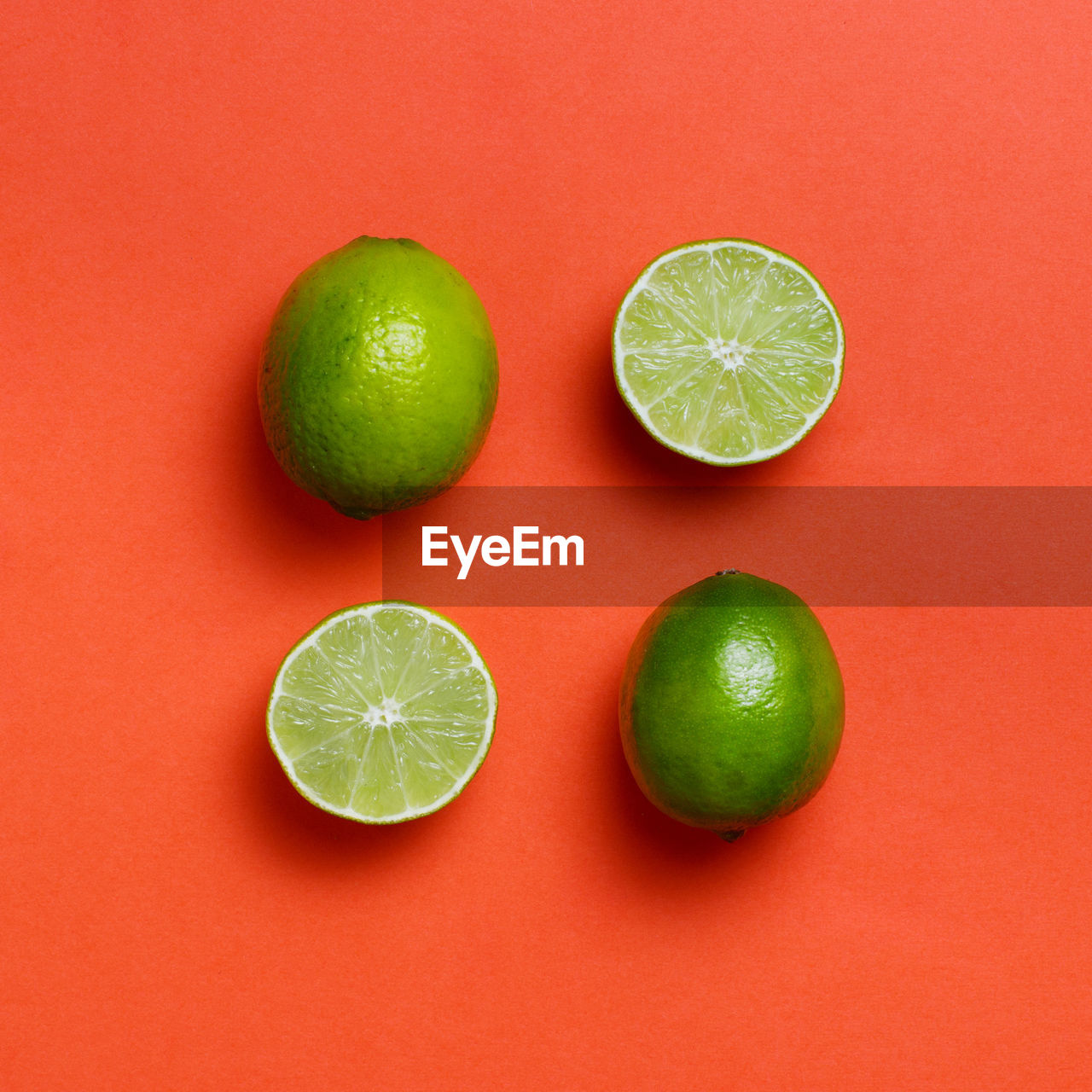 HIGH ANGLE VIEW OF GREEN FRUITS AGAINST ORANGE BACKGROUND