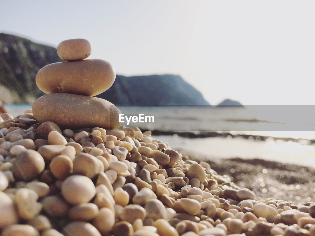Close-up of pebbles on beach against clear sky