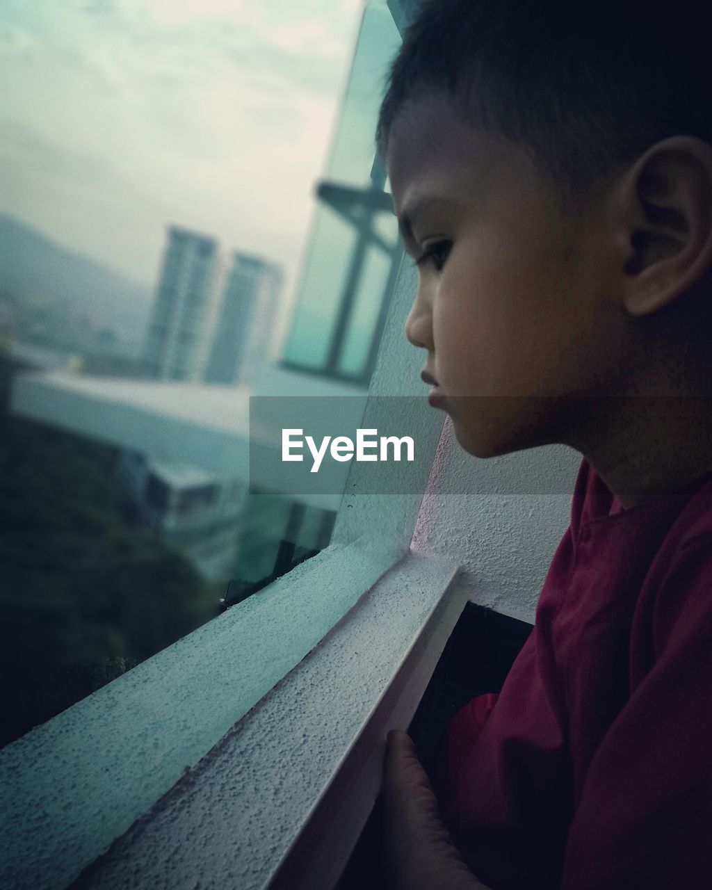 Close-up of boy looking through window