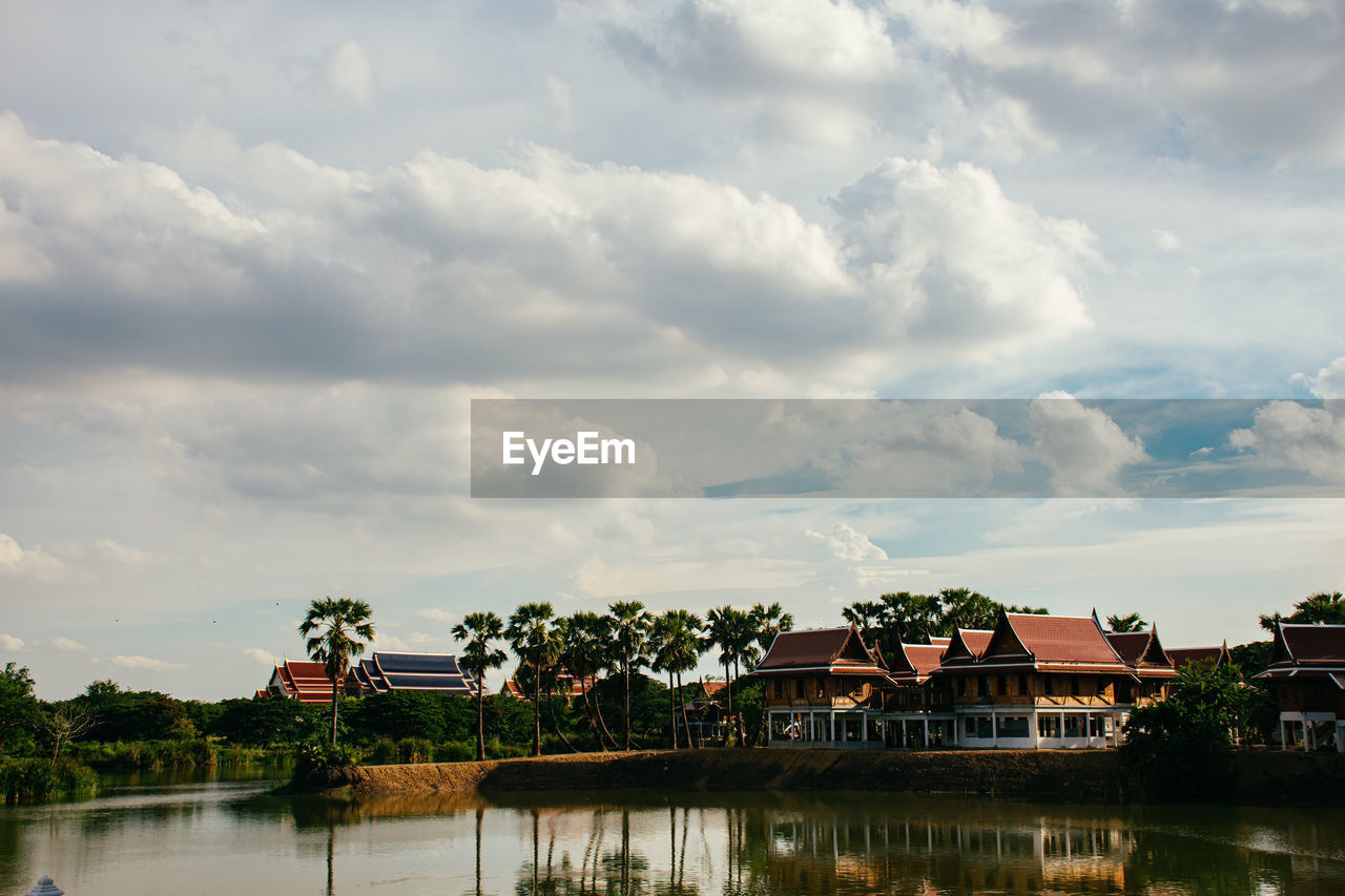 LAKE BY BUILDINGS AGAINST SKY