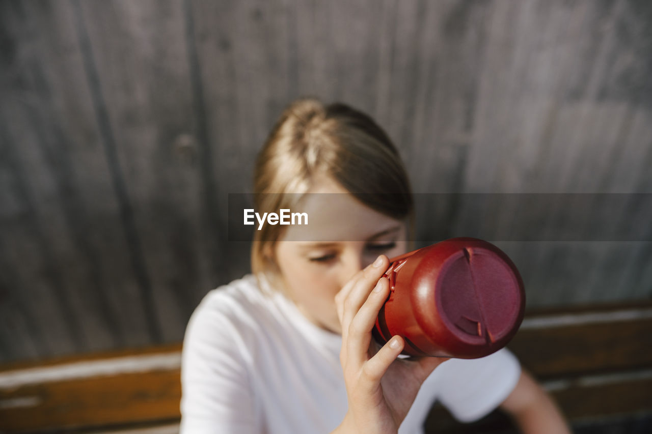 High angle view of girl drinking water at basketball court