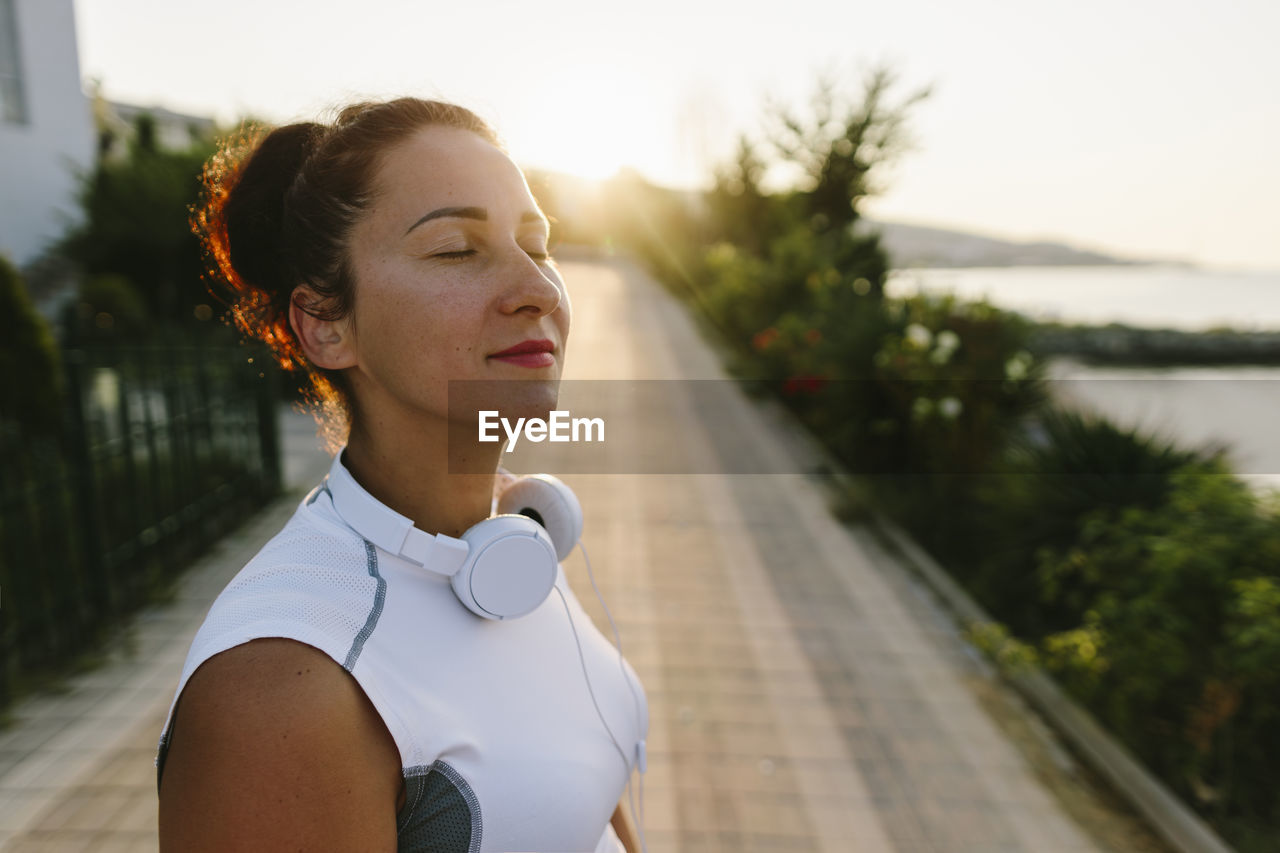 Smiling woman with eyes closed on sunny day