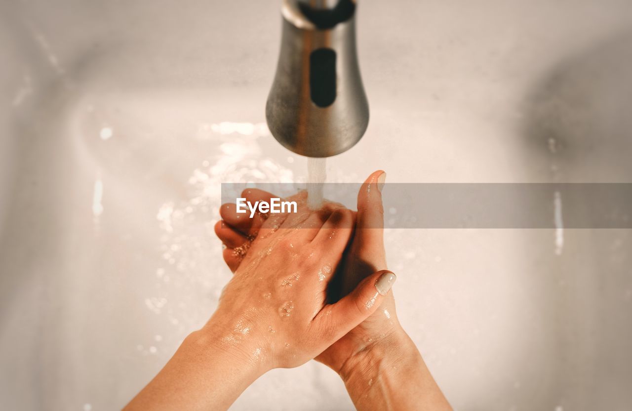 High angle view of person washing hands in sink