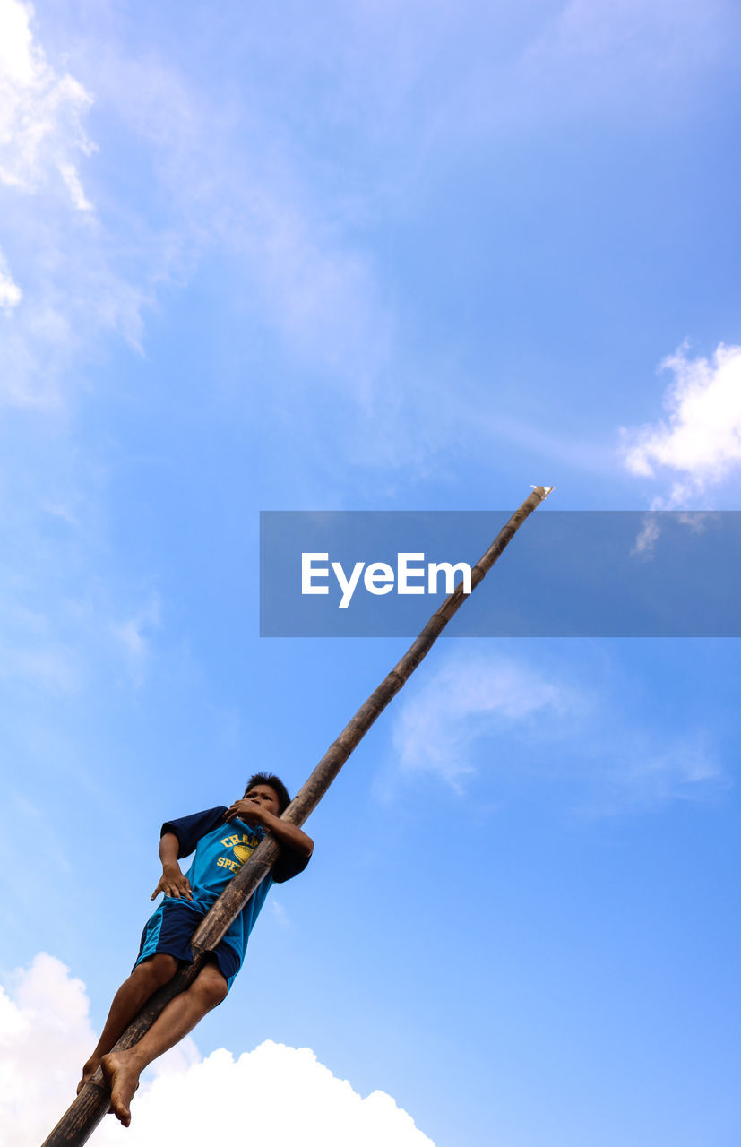 LOW ANGLE VIEW OF MAN AGAINST SKY