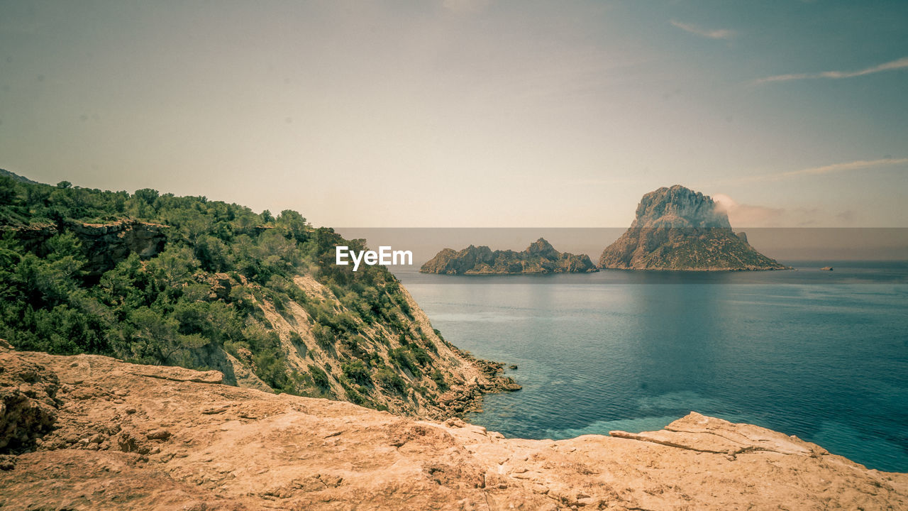 Scenic view of sea and mountains against clear sky