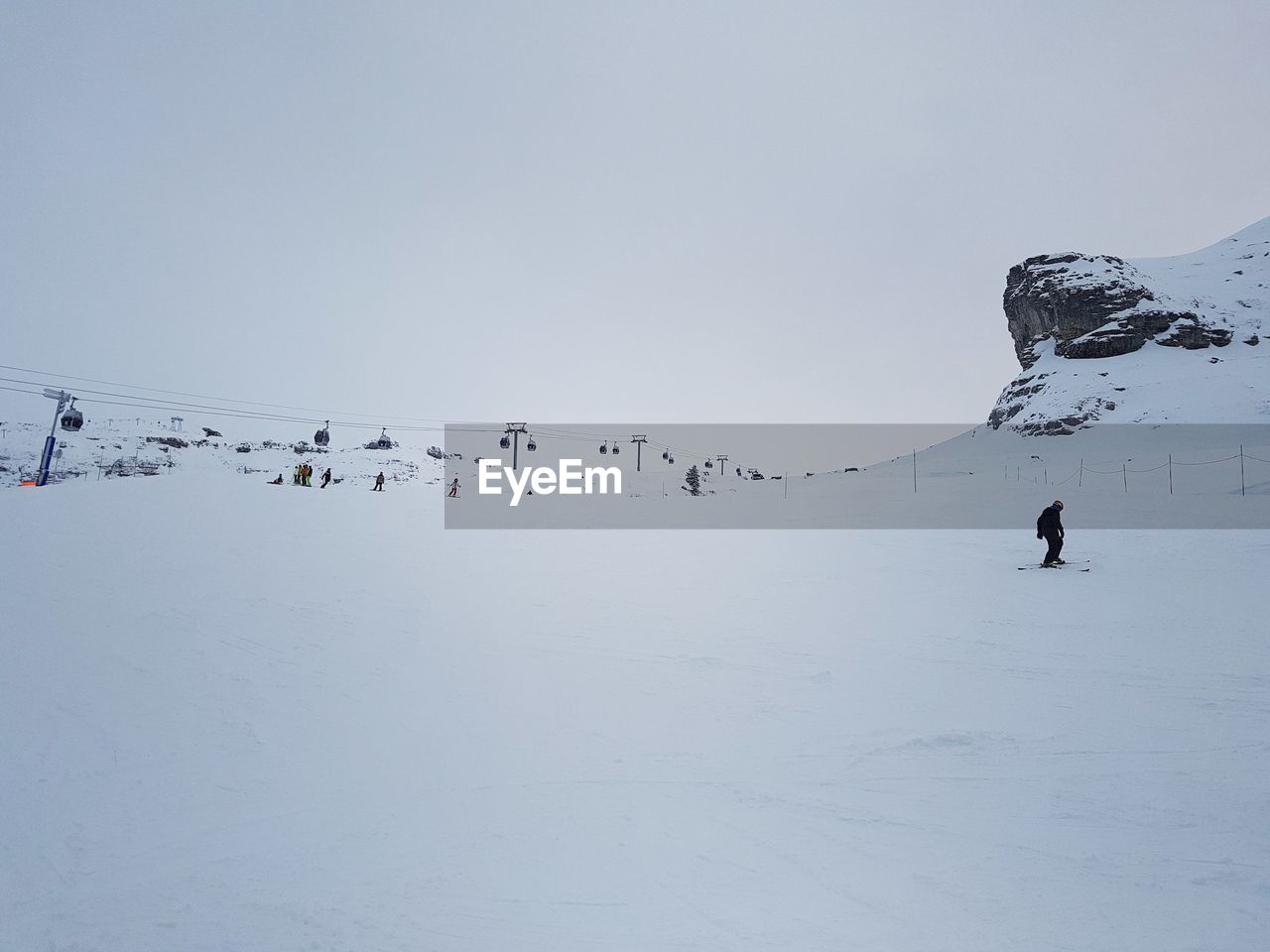 FLOCK OF BIRDS FLYING OVER SNOWCAPPED MOUNTAIN AGAINST SKY