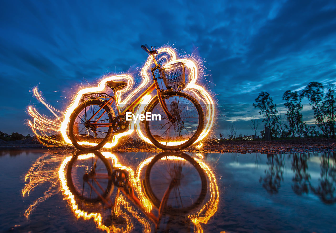 Light painting over bicycle by lake