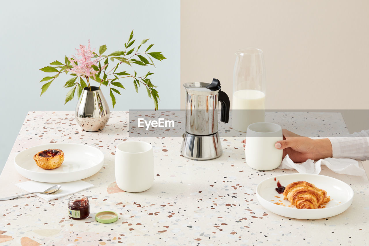 Breakfast table with a hand of a woman