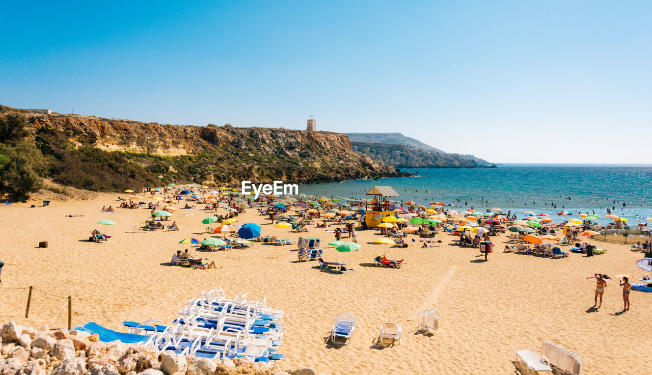 High angle view of people at beach against clear sky on sunny day