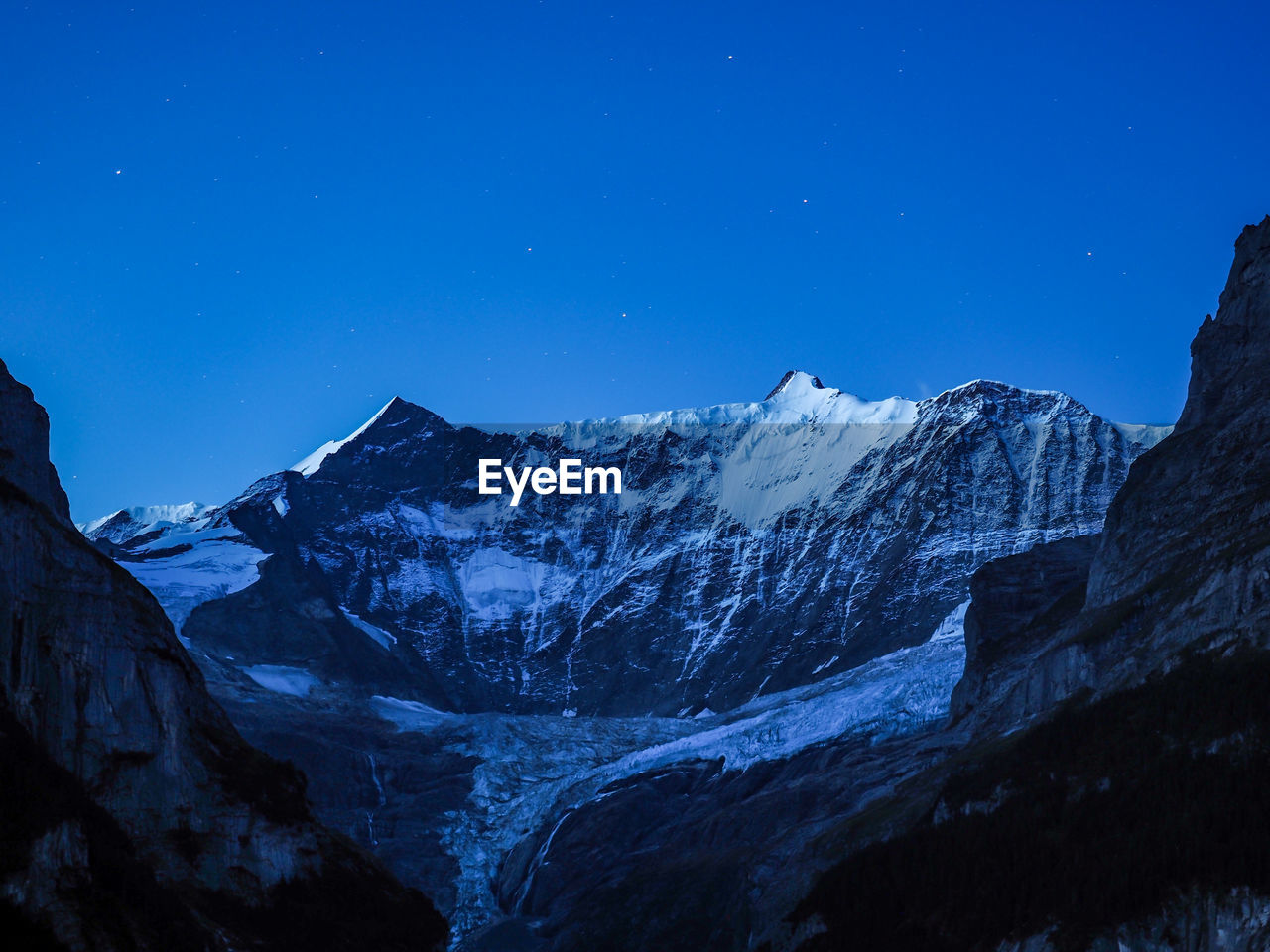 Scenic view of snowcapped mountains against clear blue sky