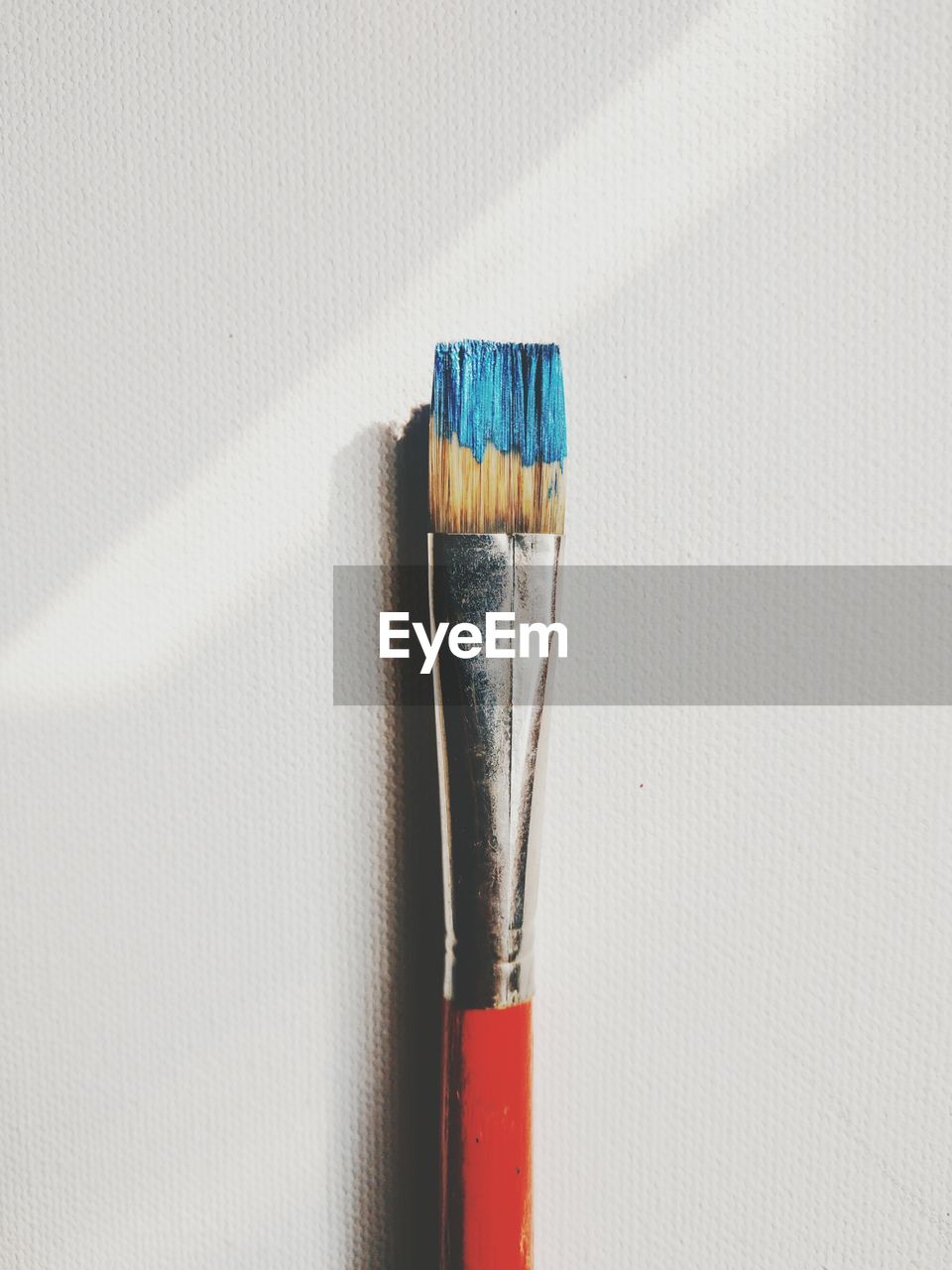 Close-up of paintbrush on white table