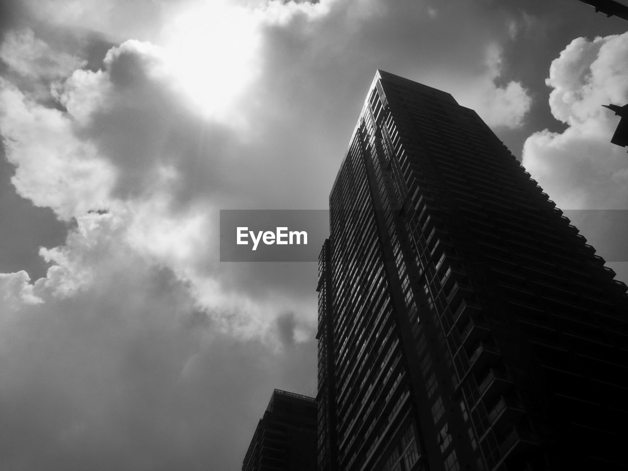 LOW ANGLE VIEW OF SKYSCRAPER AGAINST CLOUDY SKY