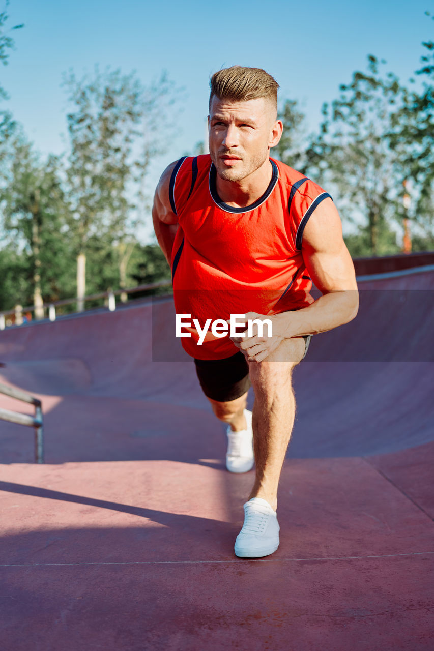 portrait of young man exercising on road