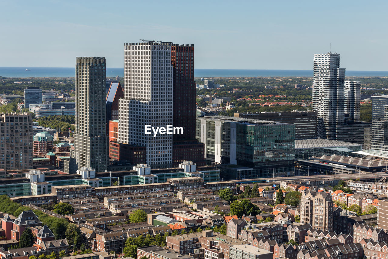 Aerial view of buildings in city against sky