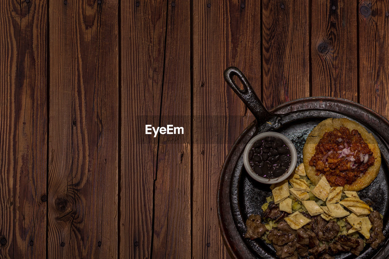 HIGH ANGLE VIEW OF FOOD SERVED ON WOODEN TABLE