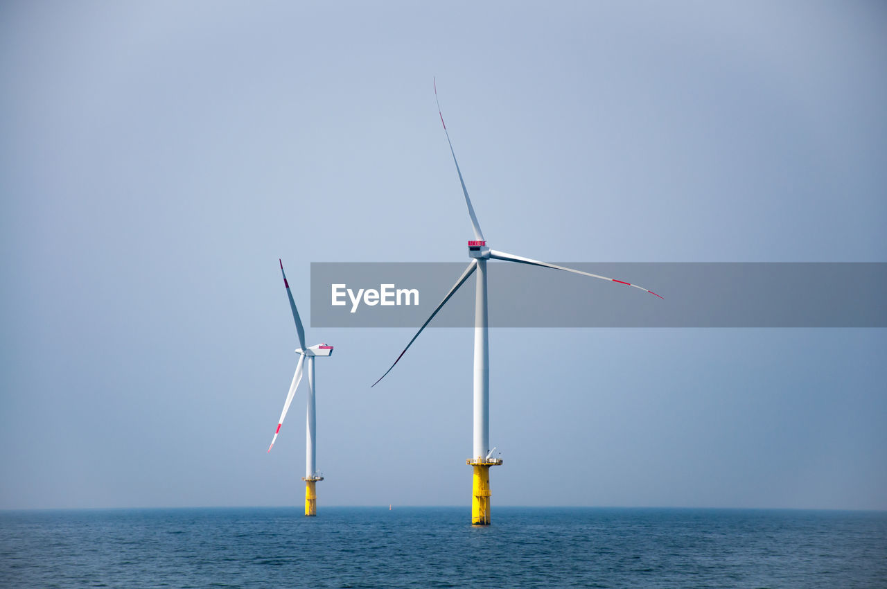 WINDMILLS ON SEA AGAINST SKY