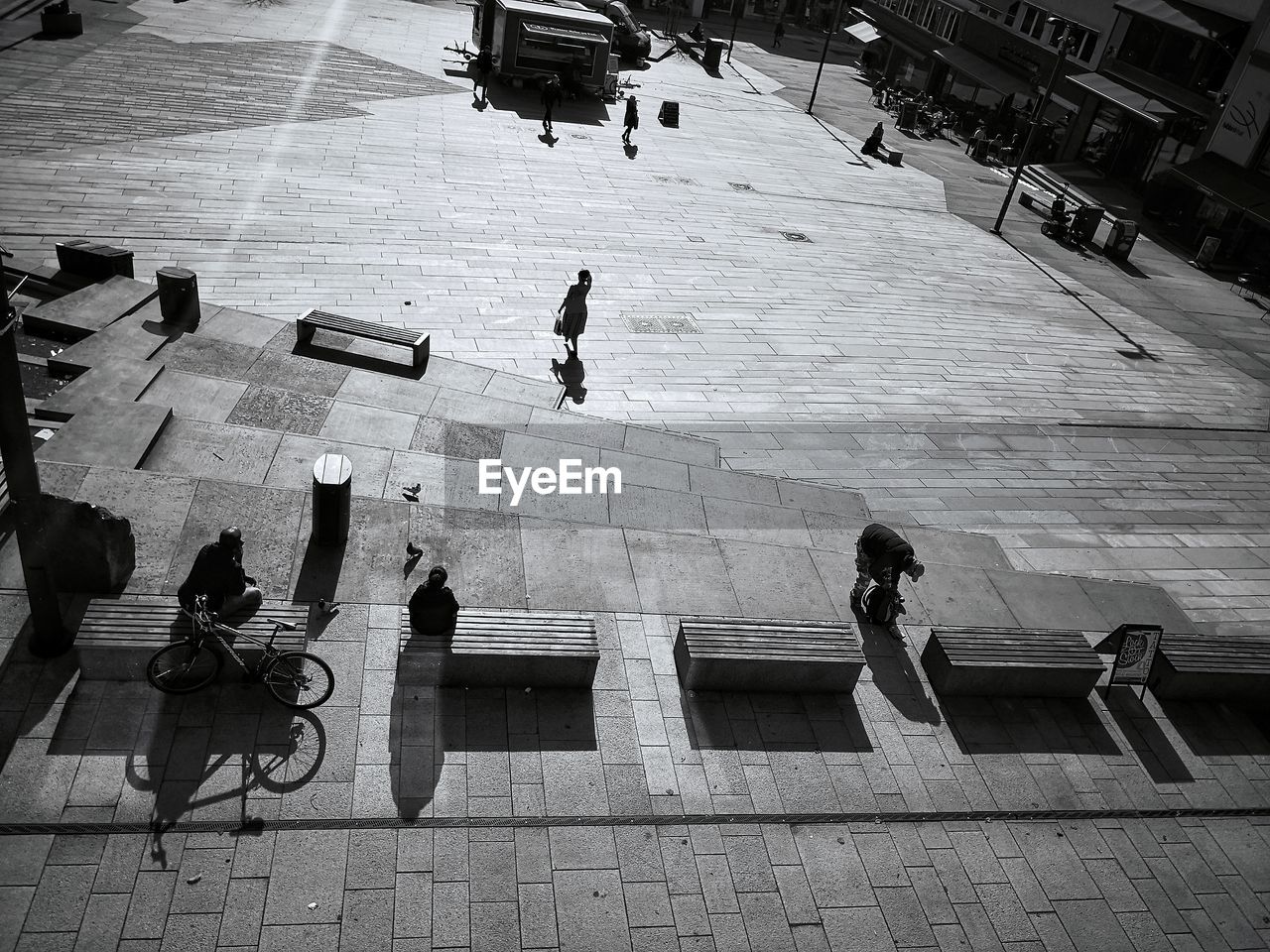 HIGH ANGLE VIEW OF PEOPLE WALKING ON COBBLESTONE STREET