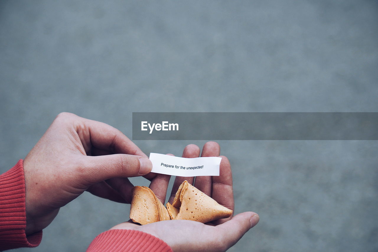 Close-up of hands holding fortune cookie