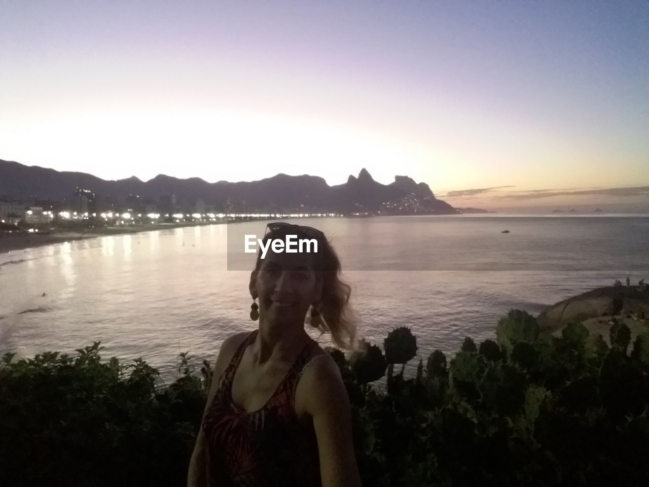 YOUNG WOMAN BY SEA AGAINST CLEAR SKY