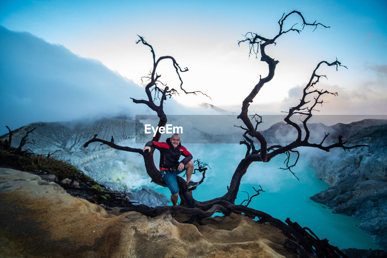 MAN SKIING ON ROCK AGAINST SKY