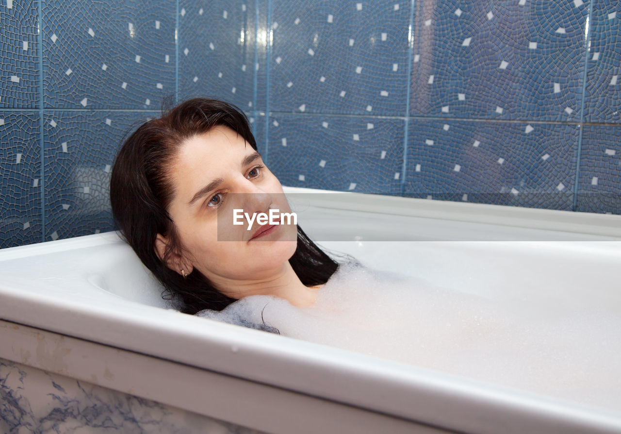 Close-up of thoughtful woman in bathtub