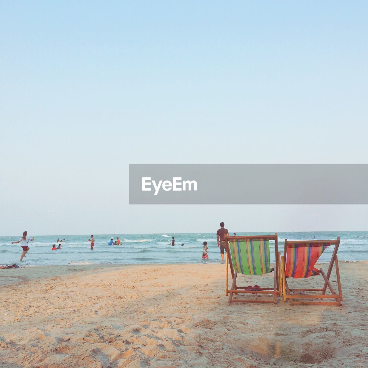 VIEW OF PEOPLE ON BEACH AGAINST CLEAR SKY