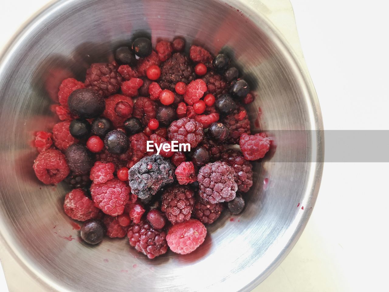 HIGH ANGLE VIEW OF RASPBERRIES IN BOWL