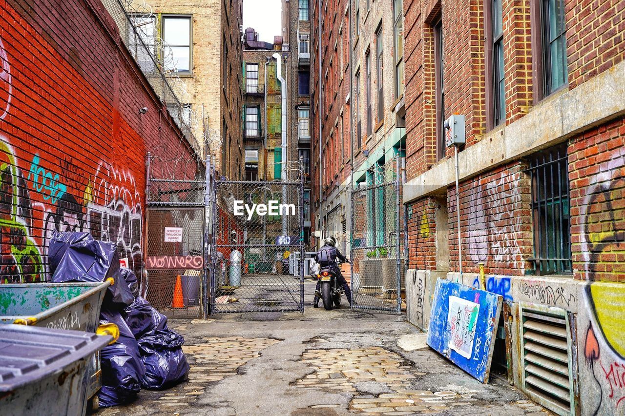 PEOPLE ON STREET AMIDST BUILDINGS