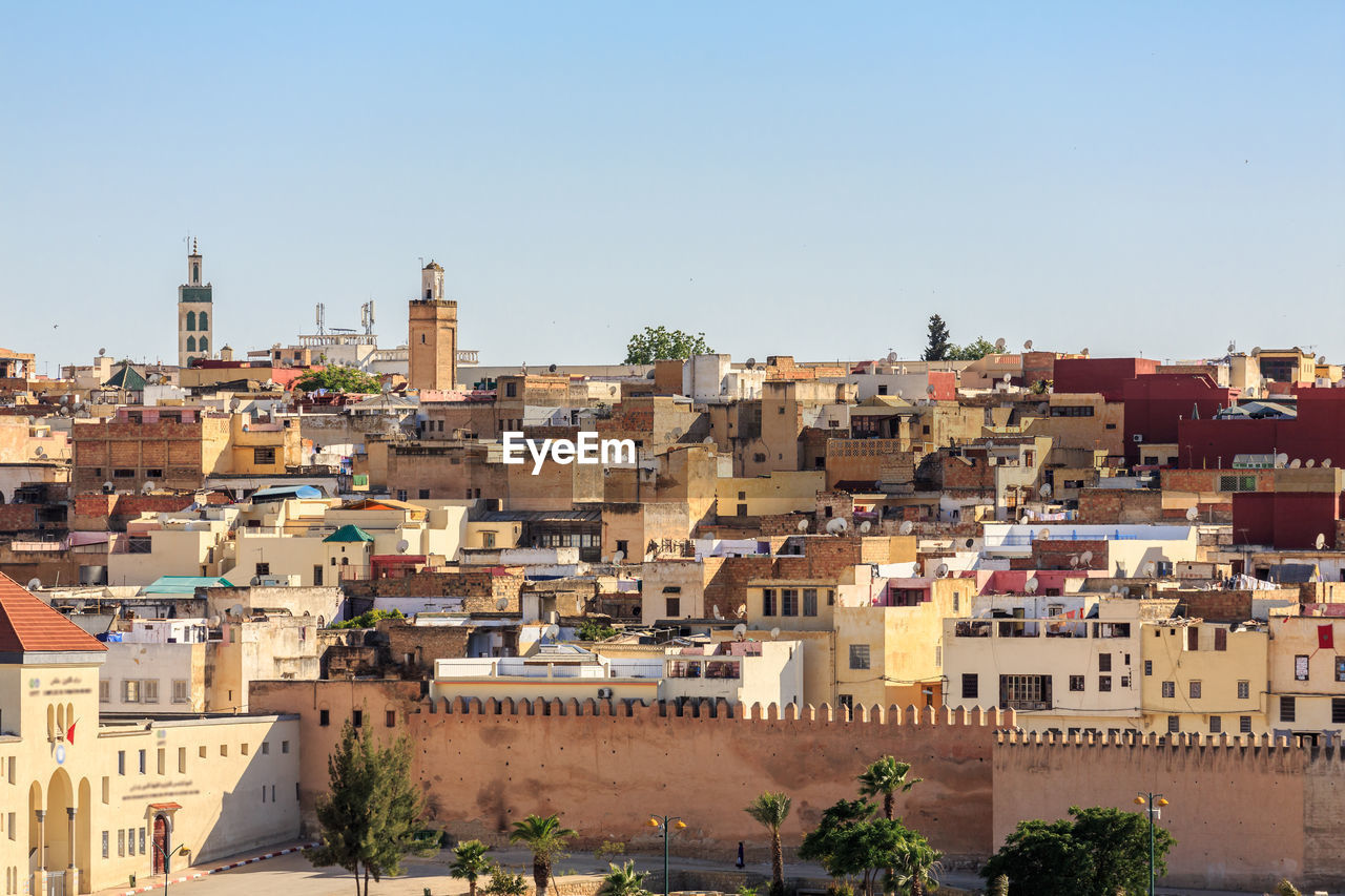 Buildings in city against clear sky